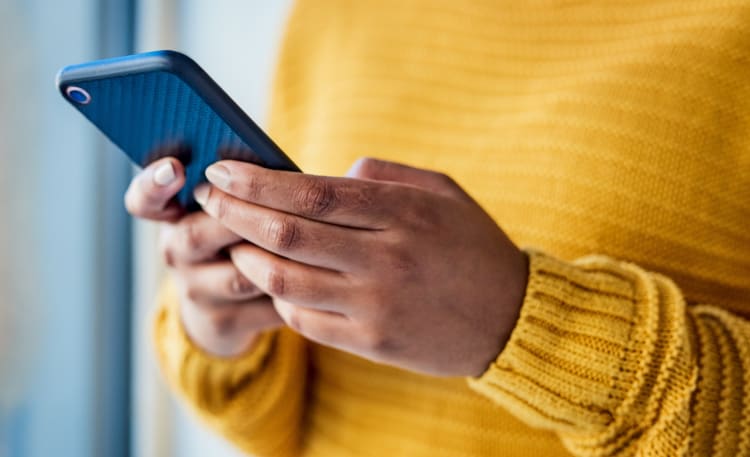 a close up look at a woman's hands holding and using her cell phone